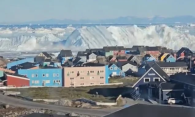 Moment enormous iceberg capsizes triggering tsunami-like waves off coastal town in Greenland