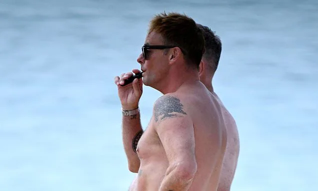Ant McPartlin, 50, is left in hysterics over shirtless beach picture of himself next to his 'larger' friend that created awkward optical illusion