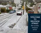 New Zealand capital delights in rare snowfall as southern city residents ski down world’s steepest street