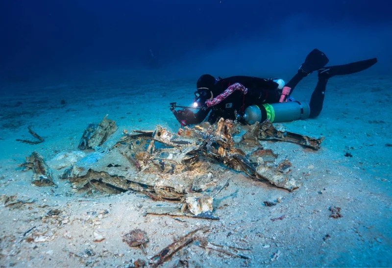Forty-five meters down, a diver races to record a fleeting moment of WWII history