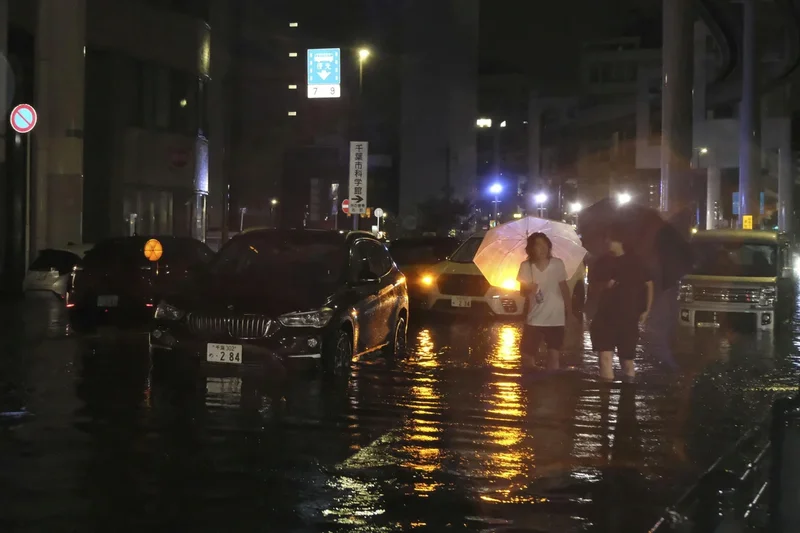 At least four dead and thousands stranded at Tokyo airport as record rain batters Japan