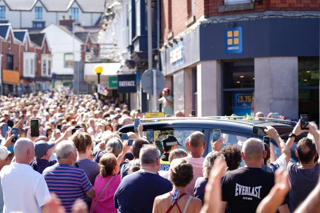 Crowd bursts into rendition of Bonnie Tyler hit as coffin returns home