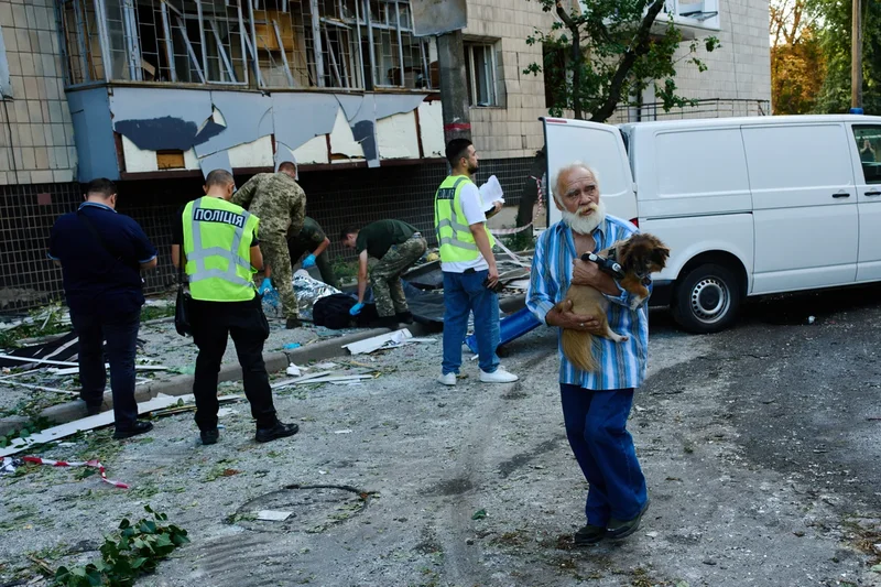 Photos show Kyiv residents clutching pets, collecting bodies after Russian missile and drone attack